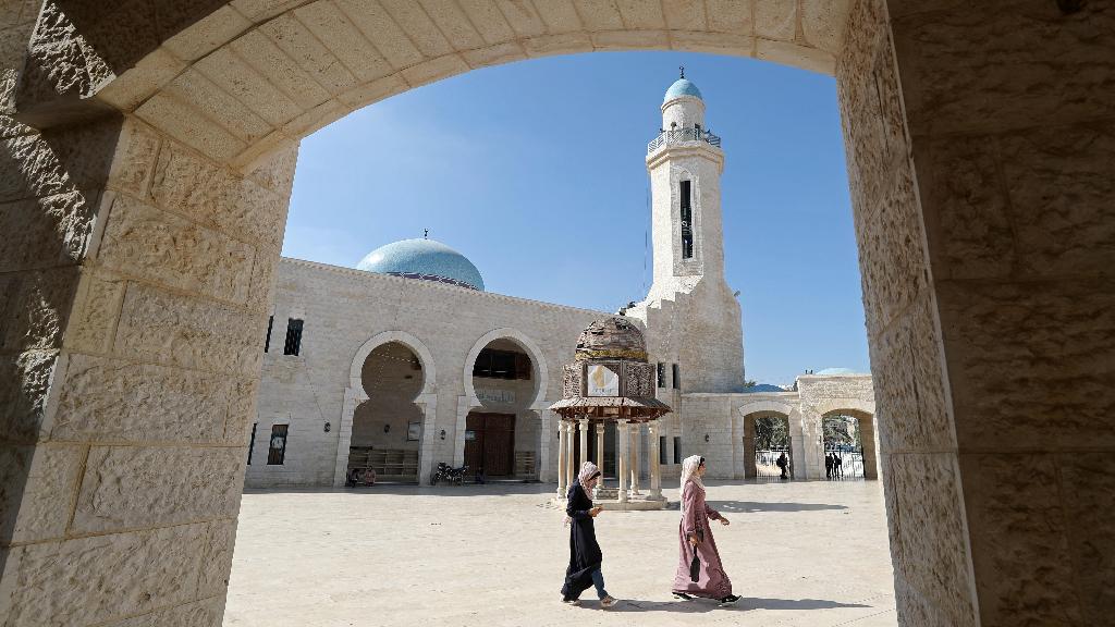 Palestinians walk at the yard of a mosque at the Sheikh Zayed housing estate in the northern Gaza Strip 