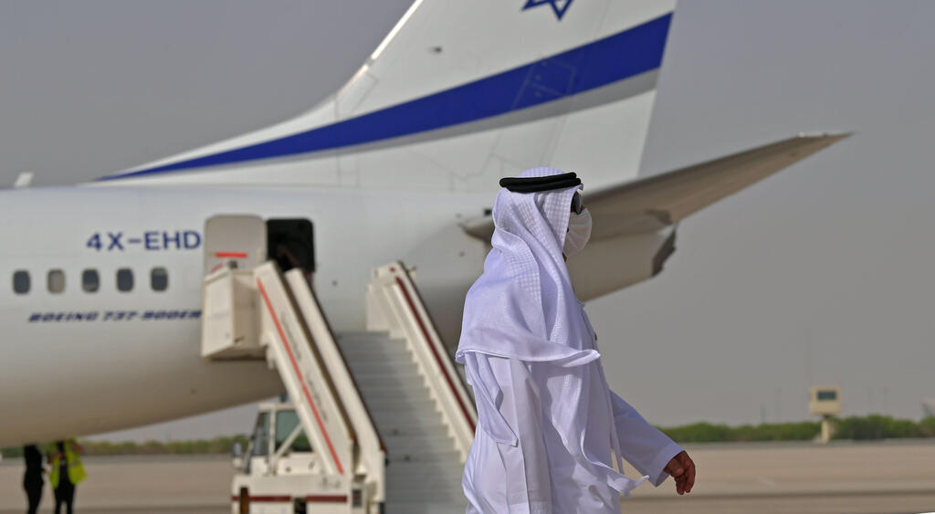 An Emirati official stands near an air-plane of El Al, which carried a US-Israeli delegation to the UAE following a normalisation accord, upon it's arrival at the Abu Dhabi airport