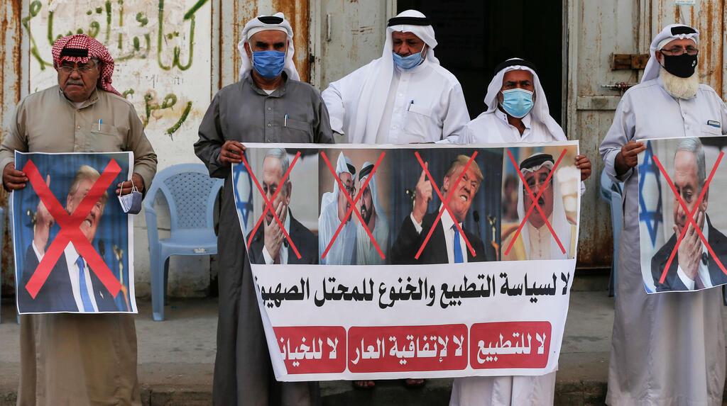 Palestinian men carry the exed out portraits of the Bahraini King, US President and Israeli Premier during a protest in Deir al-Balah, in central Gaza Strip, on September 12, 2020, to condemn the normalisation of ties between Israeli and Bahrain