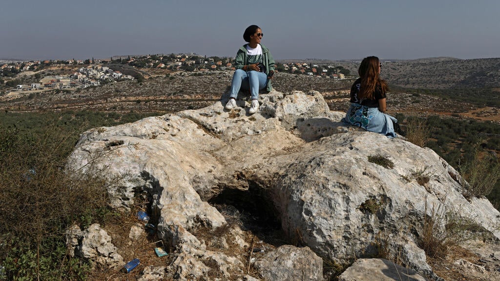 oung Palestinian travel bloggers Malak Hasan and Bisan Alhajhasan sit at the remains of an archeological site in the village of Aboud near Ramallah 