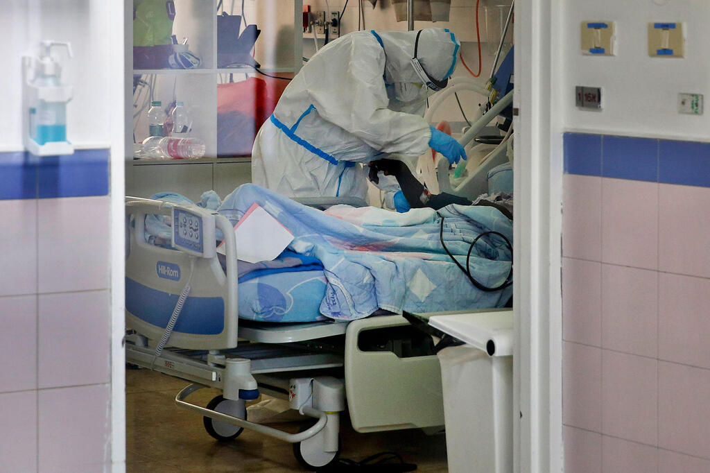 Health worker treats coronavirus patient at Barzilai Medical Center in Ashkelon 