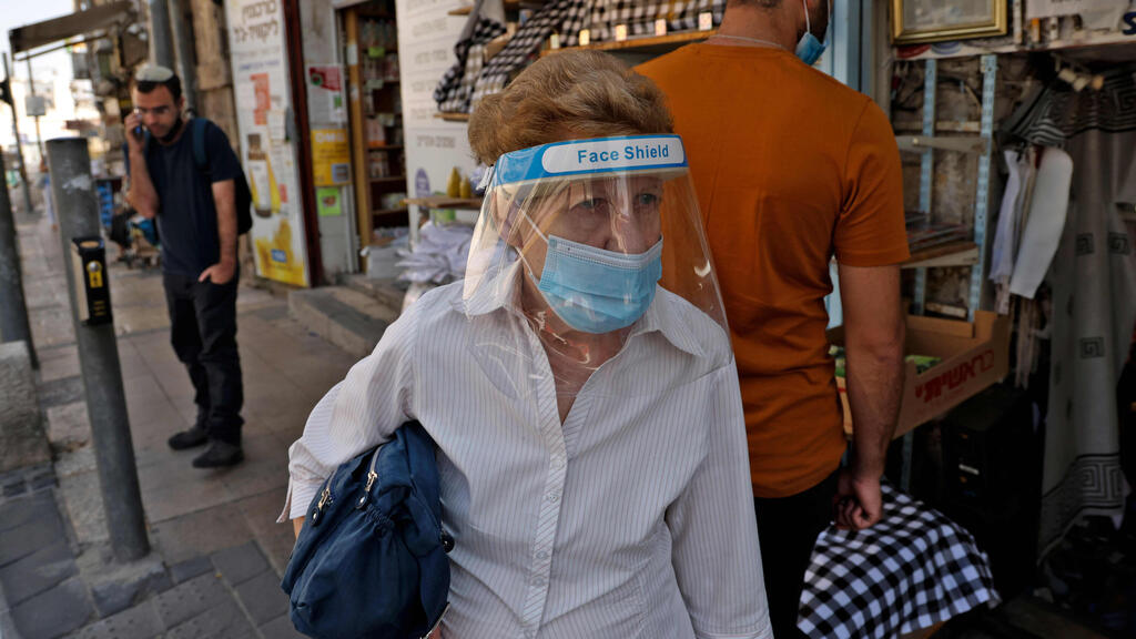  Israeli woman dons protective mask at Mahane Yehuda Market 