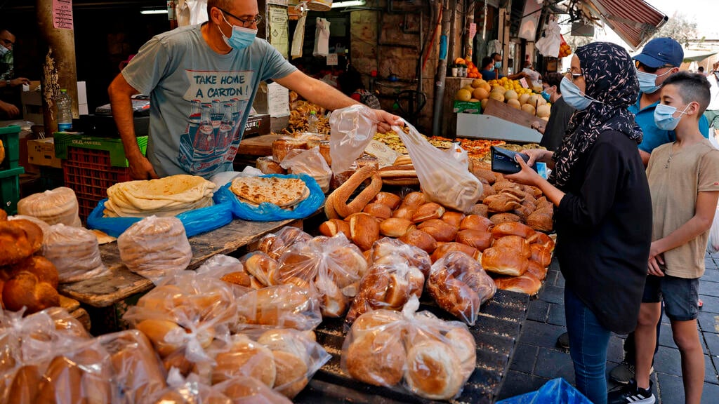 People shop for food in Jerusalem ahead of a more restrictive lockdown due to come into effect on Friday 
