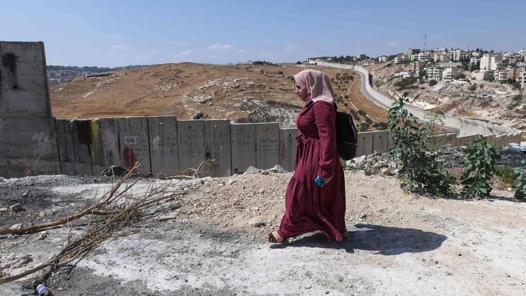 Palestinian student at Al-Quds University Aya Abu al-Amal, 18, makes her way to class along the wall separating East Jerusalem from the Palestinian village of Abu Dis 