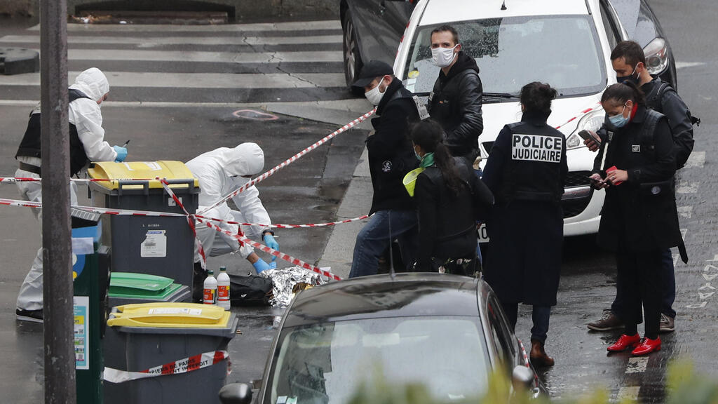 Police officers gather in the area of a knife attack near the former offices of satirical newspaper Charlie Hebdo, Friday Sept. 25, 2020 