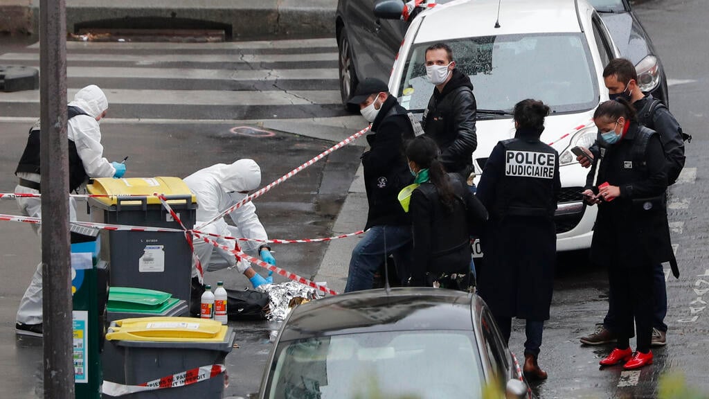 Police officers gather in the area of a knife attack near the former offices of satirical newspaper Charlie Hebdo, Friday Sept. 25, 2020 