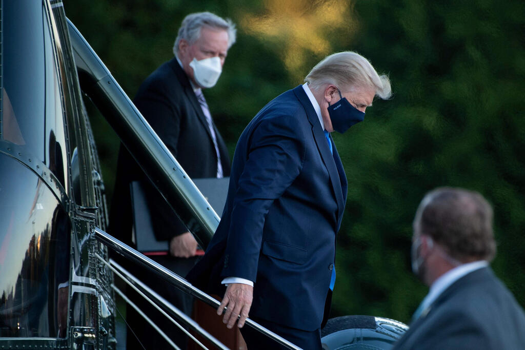 White House Chief of Staff Mark Meadows (L) watches as US President Donald Trump (C) walks off Marine One while arriving at Walter Reed Medical Center in Bethesda, Maryland 