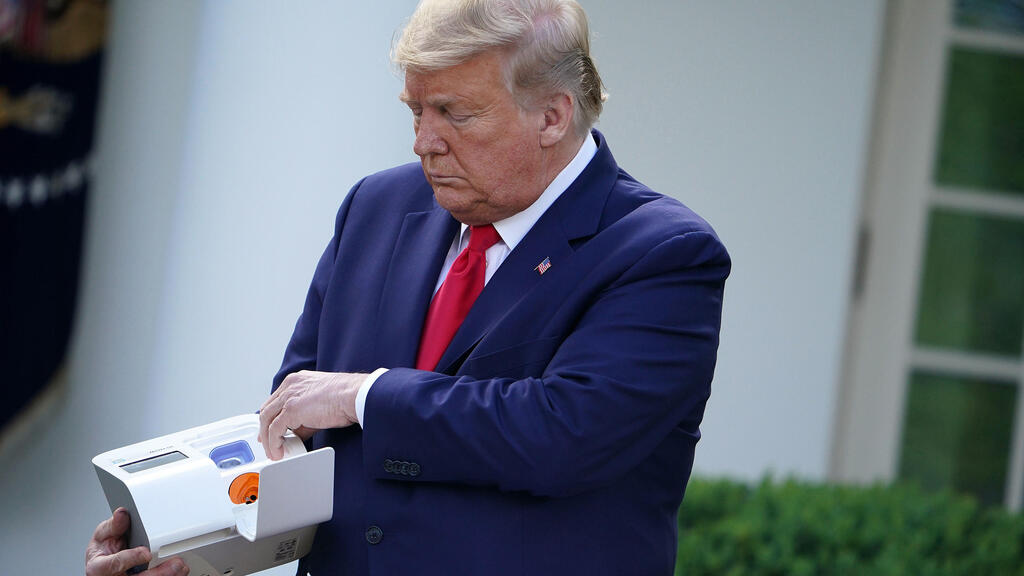 U.S. President Donald Trump holds a five-minute test for COVID-19 from Abbott Laboratories during the daily briefing on the novel coronavirus, COVID-19, in the Rose Garden of the White House on March 30, 2020 in Washington, D.C.