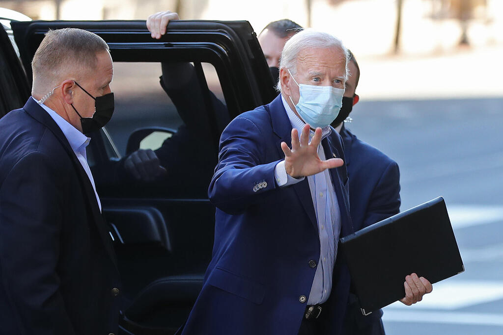 Wearing a mask against coronavirus, Joe Biden waves to reporters as he arrives at a campaign event in Delaware, Oct. 3, 2020 