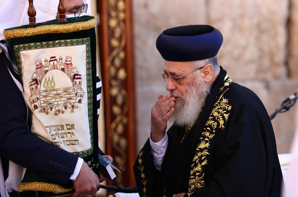 Sephardic Grand Rabbi Shlomo Amar embraces a Torah scroll during the annual Birkat Kohanim (Priestly Blessing) as part of Sukkot holiday 