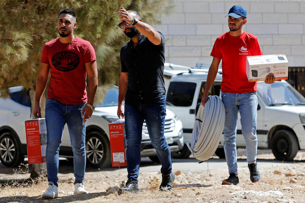 Workers arrive to install a video surveillance system to keep an eye on nearby Israeli settlers who Palestinians accuse of frequent attacks, in the village of Kisan in the Israeli-occupied West Bank 