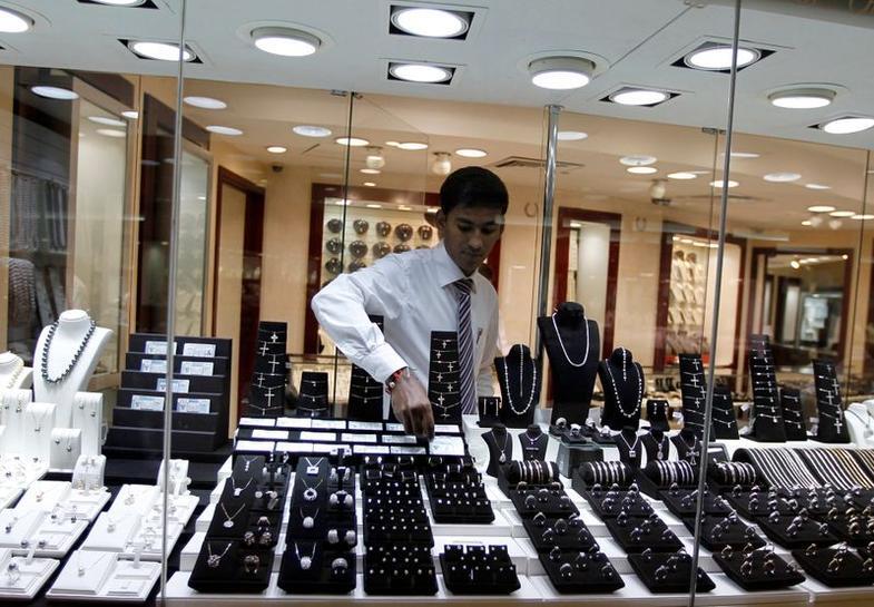 A staff member at a jewellery store places a diamond in the window display at Gold and Diamond Park, a shopping mall specialized in gold and diamond retailing, in Dubai 