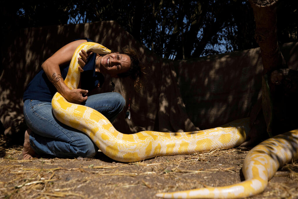 Inbar's mother, Sarit, holds their pet python Belle