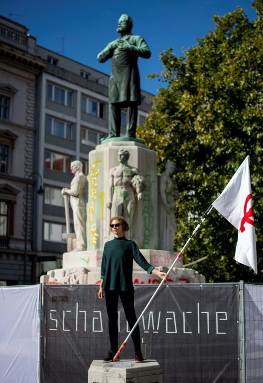 An Austrian woman stands at a vigil in front of the statue of Vienna mayor Karl Lueger 