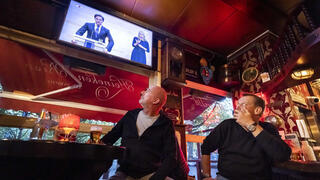 מסעדות פאבים פאב נסגרים ב גלל קורונה ב הולנד עובדים ב אמסטרדם מסתכלים על ההכרזה של ה סגר