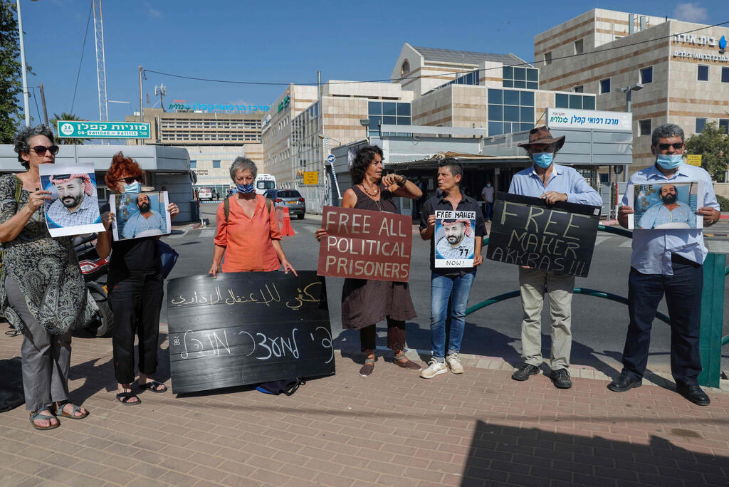 Israeli left-wing activists lift placards during a demonstration calling for the release of Palestinian administrative detainees, including Maher al-Akhras who's health has deteriorated while on hunger strike for 77 days, in front of Kaplan medical center where he is in Israeli custody in the central city of Rehovot 