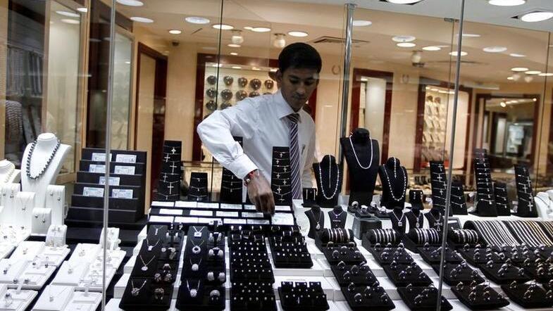 A staff member at a jewelry store places a diamond in the window display at Dubai's Gold and Diamond Park