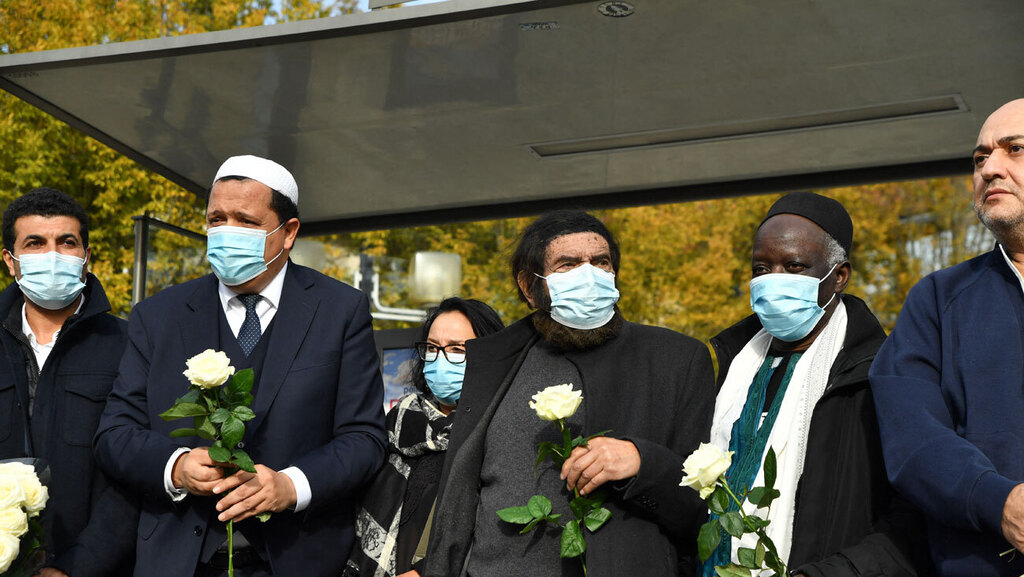 אימאם מוסלמי חסן שלגומי מניח זרי פרחים לזכר ה מורה סמואל פאטי ש נרצח ב פיגוע בפרבר של פריז צרפת