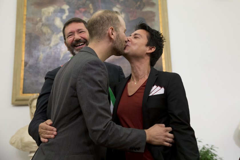 Rome’s Mayor Ignazio Marino, left, smiles as Jonathon Dominic Spada, center, and Fabrizio Maffeo kiss after their gay marriage was registered, in Rome, Saturday, Oct. 18, 2014