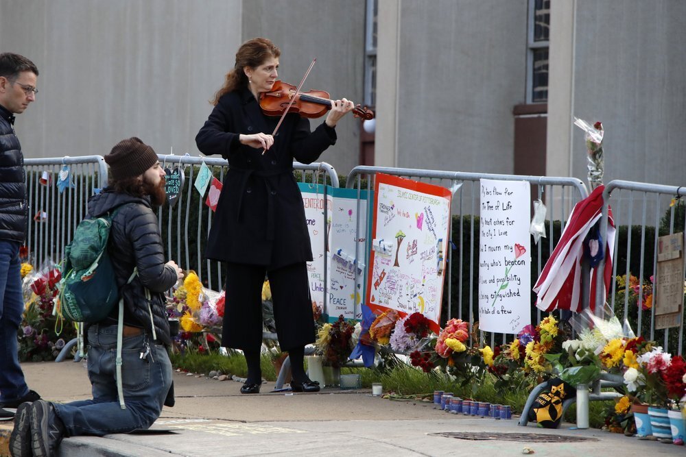 Monique Mead plays her violin on the sidewalk outside the Tree of Life synagogue in Pittsburgh on the first anniversary of the shooting at the synagogue 