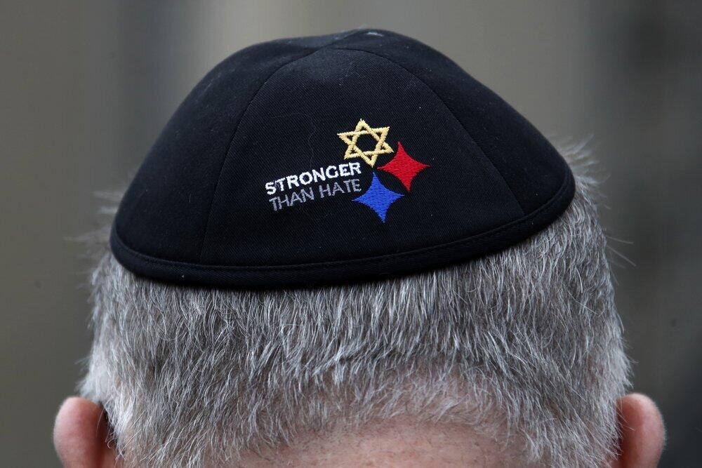 a man wearing a "Stronger Than Hate" yarmulke stands outside the Tree of Life synagogue in Pittsburgh on the first anniversary of the shooting at the synagogue, 
