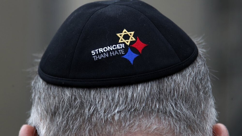 a man wearing a "Stronger Than Hate" yarmulke stands outside the Tree of Life synagogue in Pittsburgh on the first anniversary of the shooting at the synagogue, 