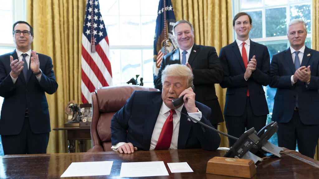 President Donald Trump talks on a phone call with the leaders of Sudan and Israel, as Treasury Secretary Steven Mnuchin, left, Secretary of State Mike Pompeo, White House senior adviser Jared Kushner, and National Security Adviser Robert O'Brien, applaud