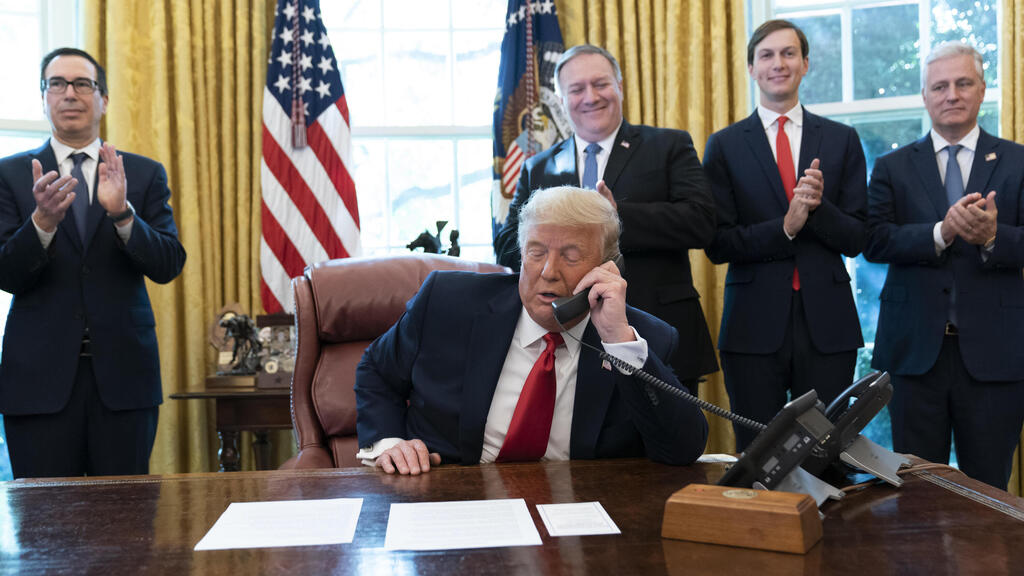 President Donald Trump talks on a phone call with the leaders of Sudan and Israel, as Treasury Secretary Steven Mnuchin, left, Secretary of State Mike Pompeo, White House senior adviser Jared Kushner, and National Security Adviser Robert O'Brien, applaud