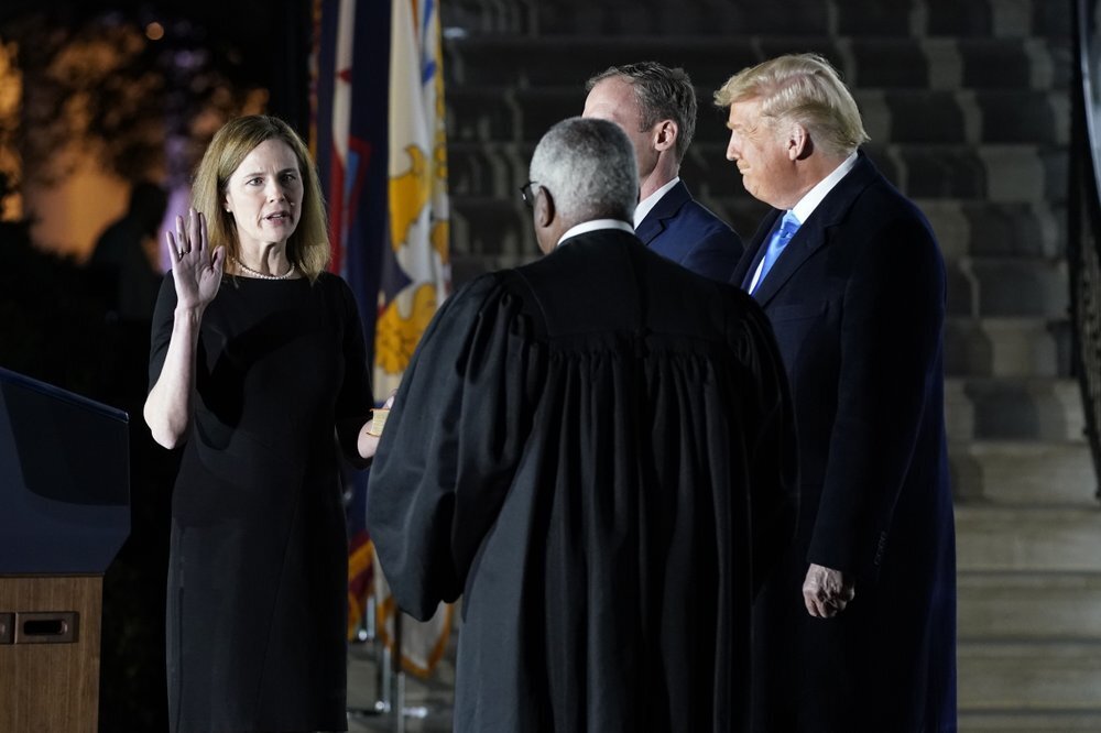 President Donald Trump watches as Supreme Court Justice Clarence Thomas administers the Constitutional Oath to Amy Coney Barrett on the South Lawn of the White House in Washington 