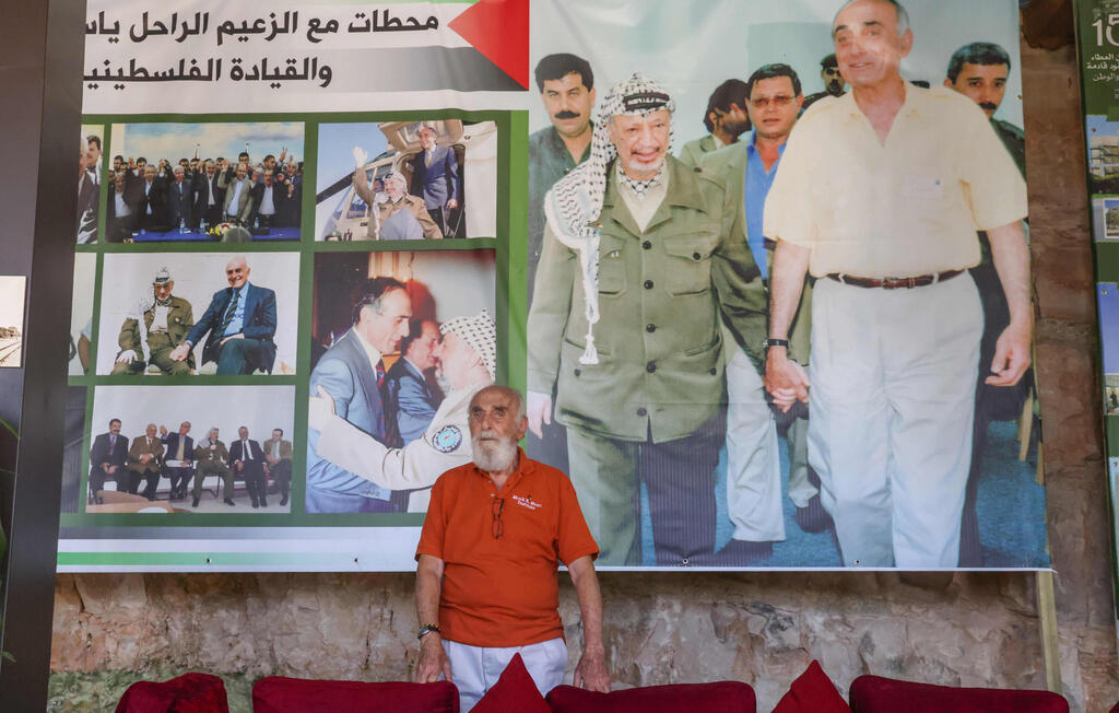 Palestinian billionaire Munib al-Masri stands in front of a poster depicting iconic Palestinian leader Yasser Arafat at a gallery dedicated for the history of Palestinians' struggle, at his mansion Beit al-Falestine (Palestine House) in the occupied West Bank city of Nablus 