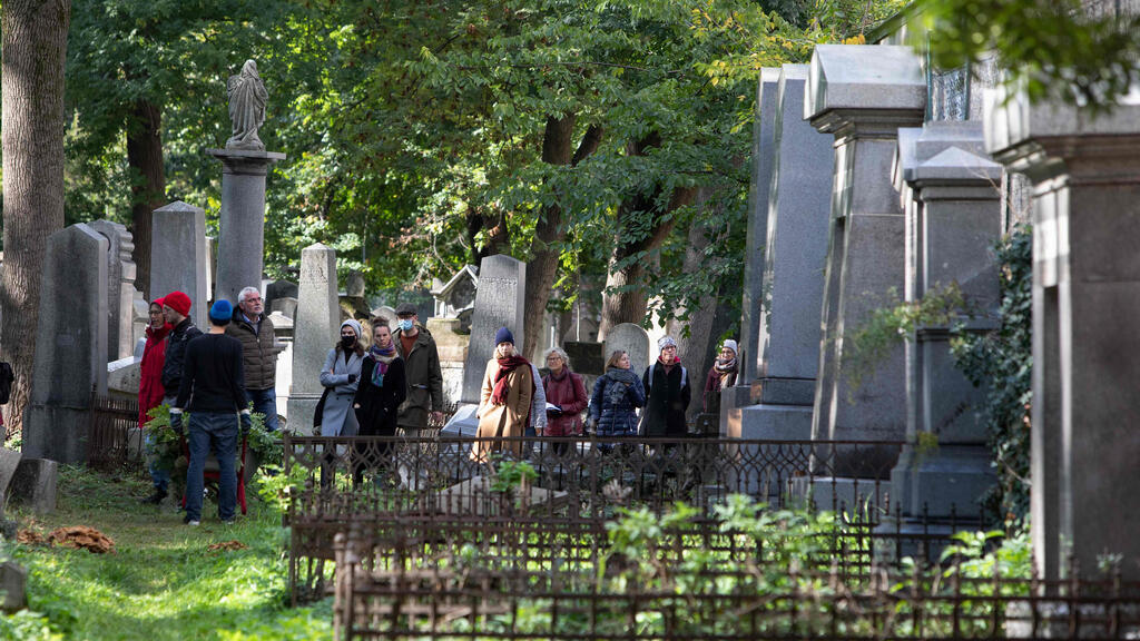 A group of visitors take part in a tour at the old Waehring Jewish cemetery