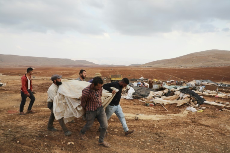 Palestinian Bedouins with their scattered belongings after Israeli soldiers demolished their tents in an area east of the village of Tubas in the occupied West Bank 