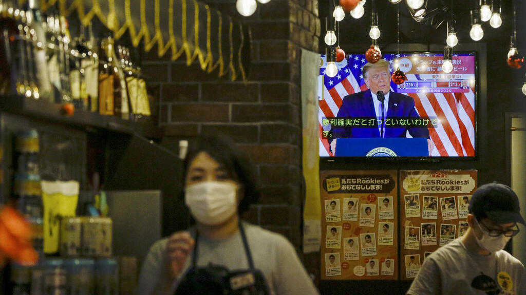 President Donald Trump speaking from the White House is projected on a television at a restaurant
