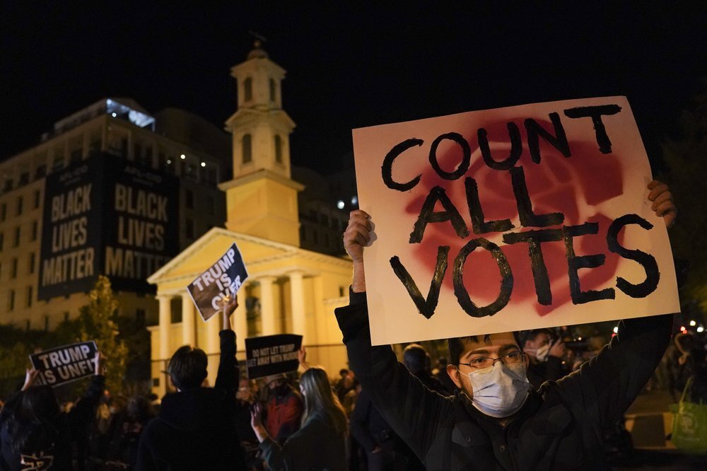 A demonstrator holds up a sign while waiting for election results at Black Lives Matter Plaza, Tuesday, Nov. 3, 2020, in Washington. 