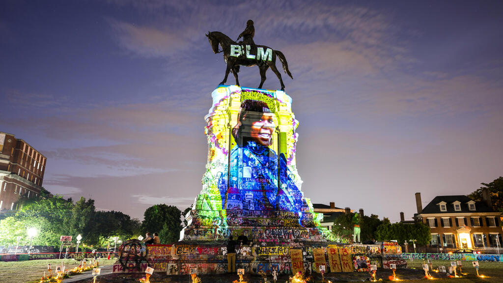 A photograph of Breonna Taylor, who was killed in her own apartment by Louisville police officers, is projected onto a statue of Confederate General Robert E. Lee 