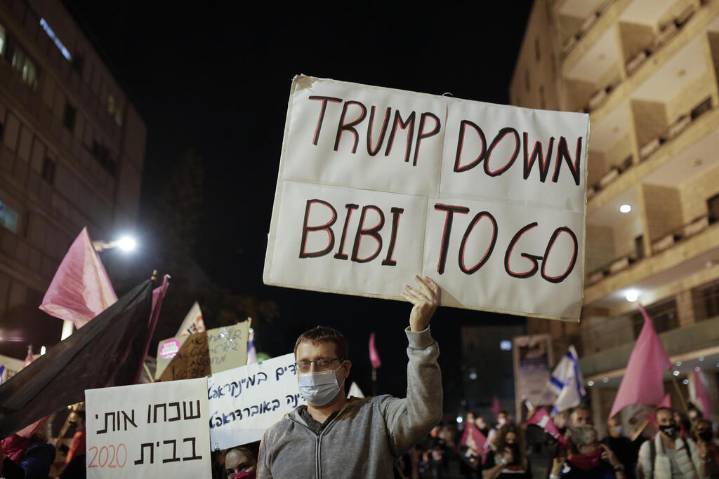 An Israeli protester holds a sign calling for the ouster of Prime Minister Benjamin Netanyahu, using his nickname "Bibi," shortly after results of the U.S. presidential election were announced, during a protest against Netanyahu in Jerusalem 
