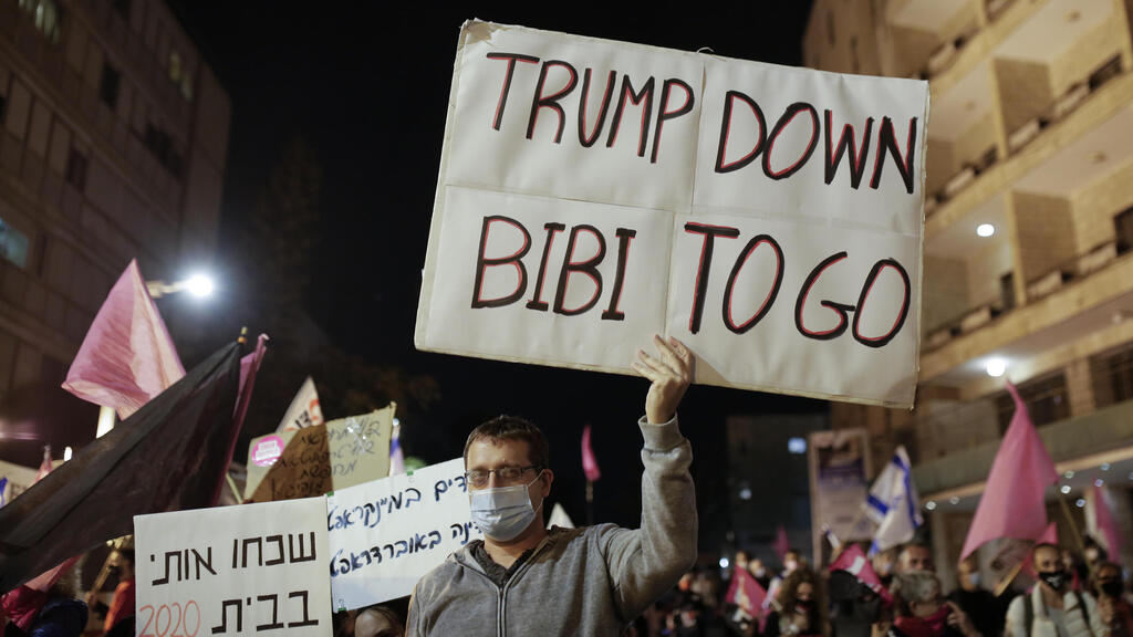 An Israeli protester holds a sign calling for the ouster of Prime Minister Benjamin Netanyahu, using his nickname "Bibi," shortly after results of the U.S. presidential election were announced, during a protest against Netanyahu in Jerusalem 