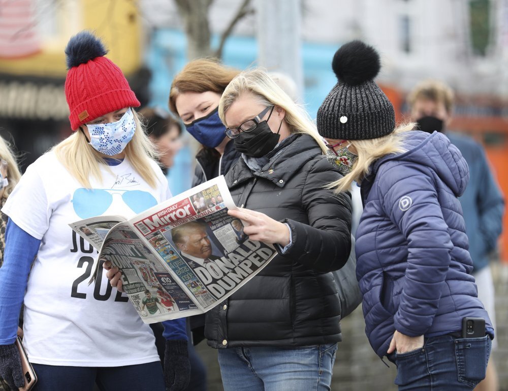 Residents read a copy of their local paper in the town of Ballina, North West of Ireland, the ancestral home of President elect Joe Biden 