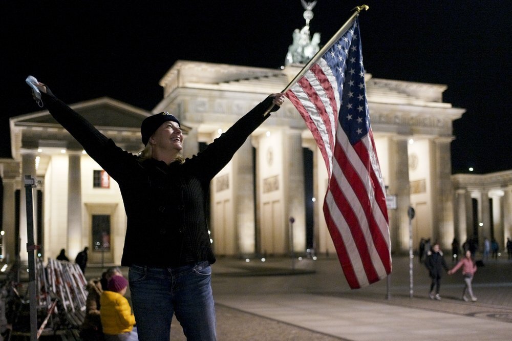 Marianne Hoenow from Connecticut in the US celebrates the victory of President-elect Joe Biden and Vice President-elect Kamala Harris in front of the Brandenbug Gate next to the United States embassy in Berlin, Germany 