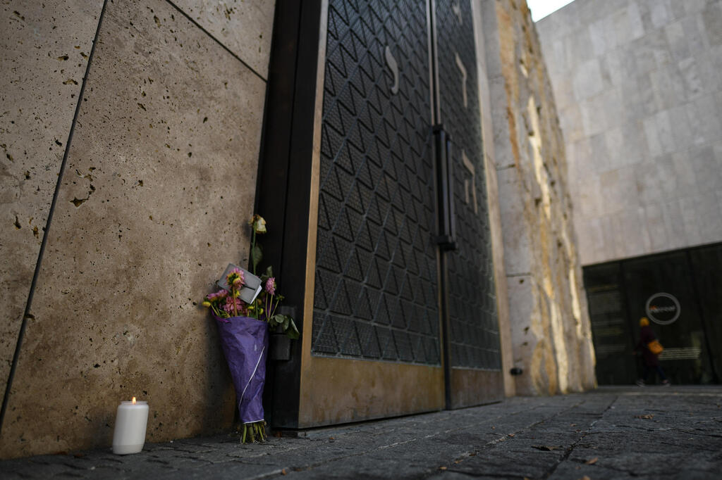 Flowers and a candle are placed next to the gate of the contemporary Ohel-Jakob-Synagogue in Munich to commemorate the victims of  the "Night of Broken Glass"