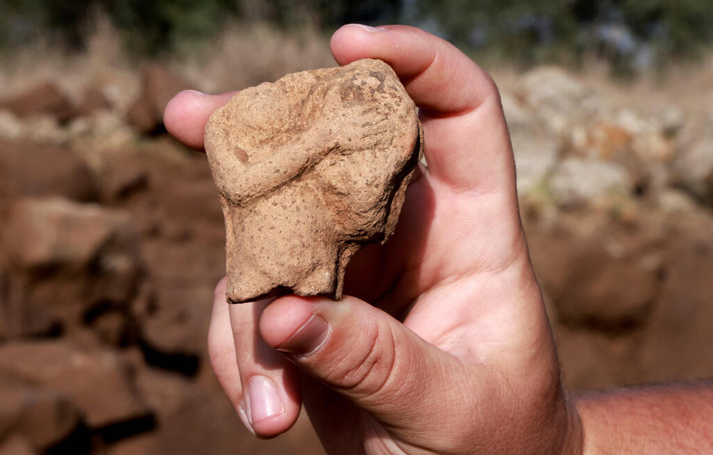 An Israel Antiquities Authority (IAA) archeologist shows a fertility figurine of a woman with a drum found at a fortified complex from the time of King David which was exposed for the first time in archaeological excavations carried out by IAA in the Hispin settlement in the Israeli-annexed Golan Heights 