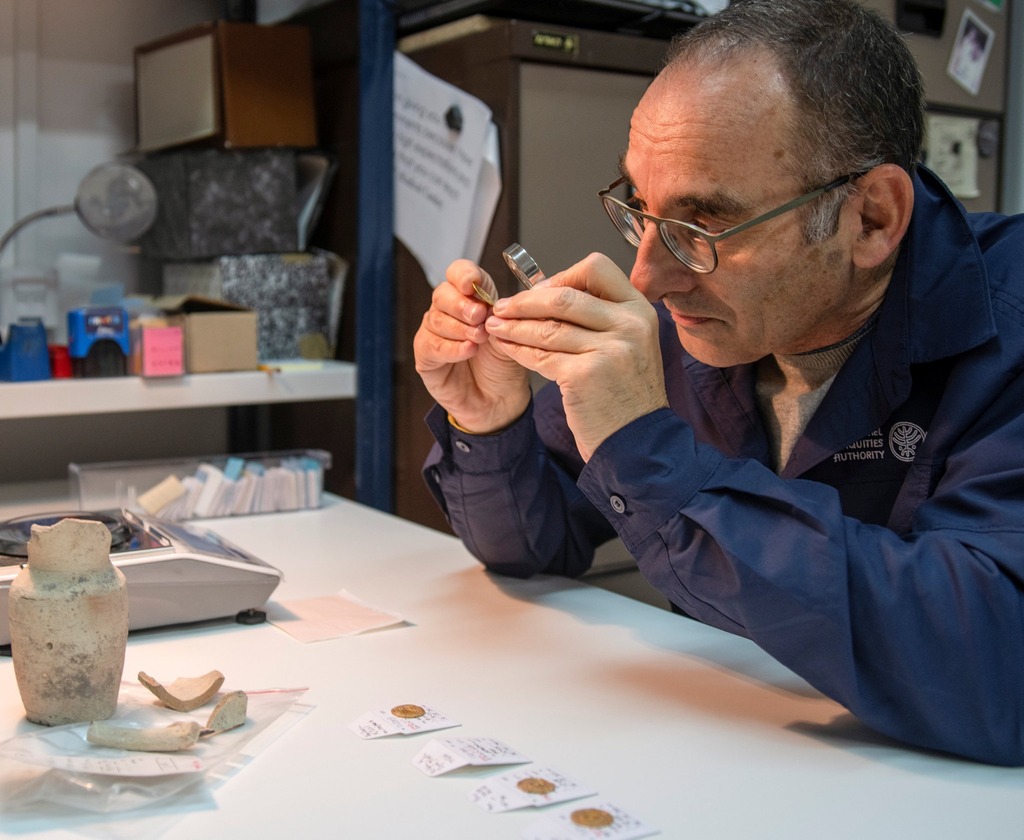 Dr. Robert Kool, IAA coin expert examines a gold coin discovered in an archeological dig in Jerusalem 
