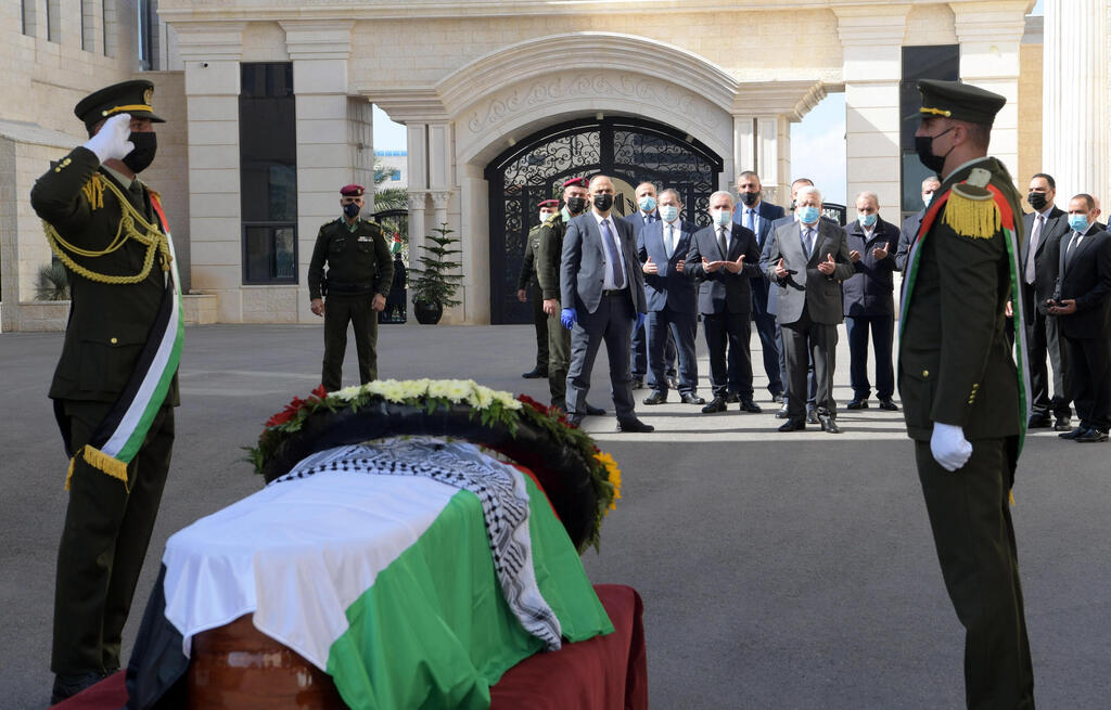 Palestinian President Mahmoud Abbas (C) praying near the coffin of late Palestinian politician and diplomat Saeb Erekat, during an official funeral procession at the Palestinian Presidential headquarter in the West Bank city of Ramallah 