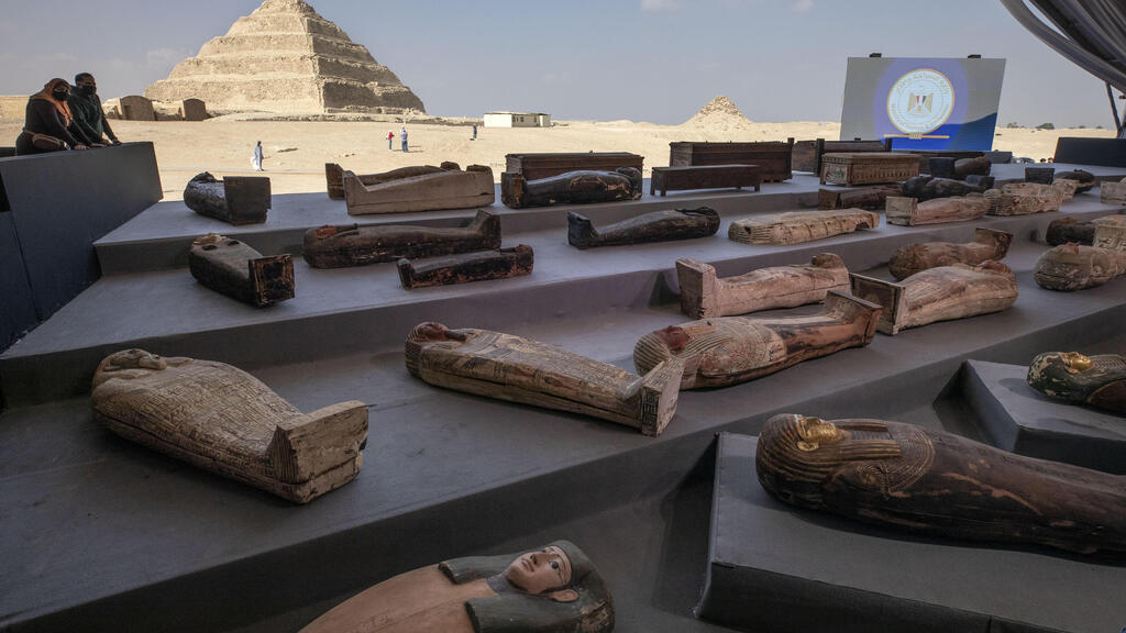 People look at ancient sarcophagi on display, discovered in a vast necropolis in Saqqara