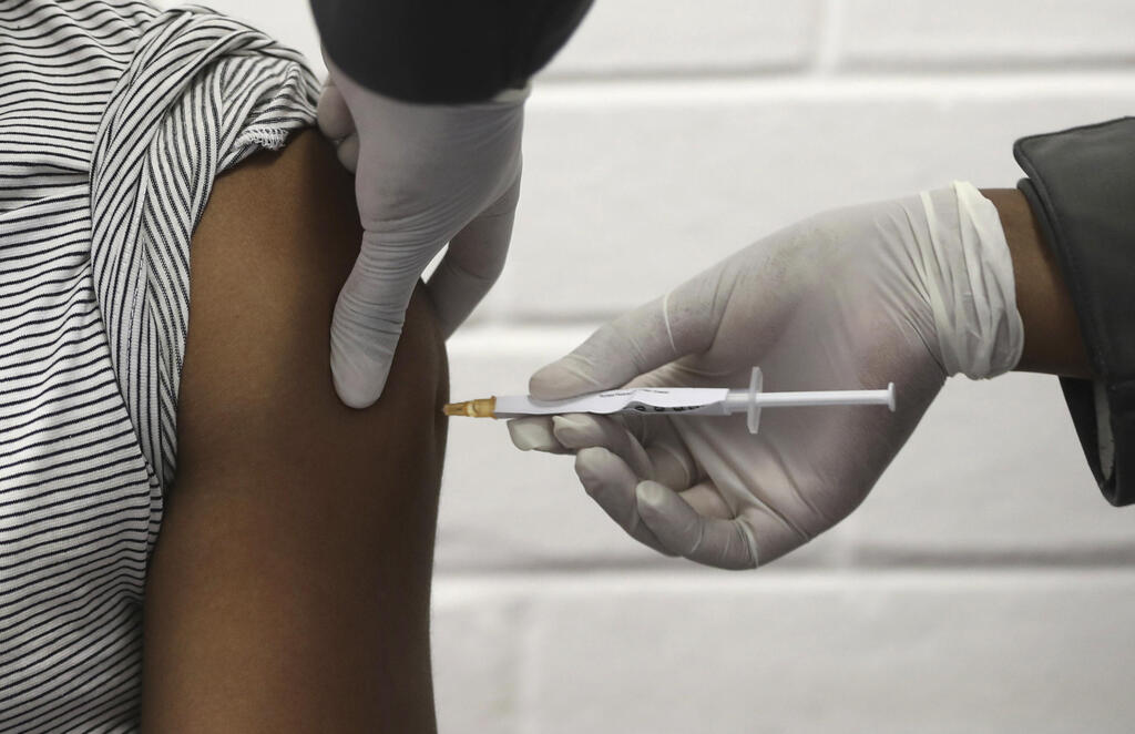 A volunteer receives an injection at the Chris Hani Baragwanath hospital in Johannesburg as part of AstraZeneca's COVID-19 vaccine trial, June 2020 