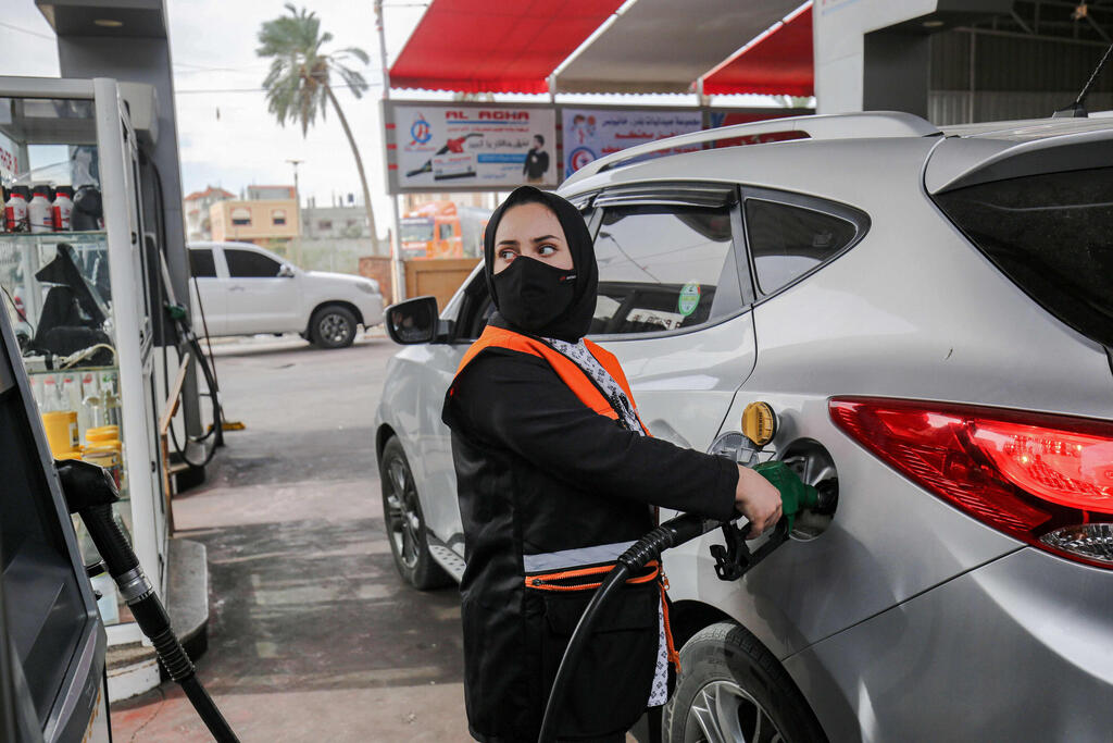 Salma al-Najjar, a 16-year-old Palestinian who works at a petrol station to help her family with income, refuels a car in Khan Yunis in southern Gaza Strip 