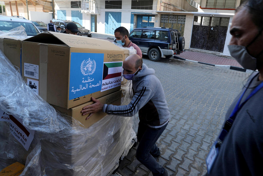 A worker unloads boxes containing ventilators delivered by the World Health Organization (WHO) and donated by Kuwait, in Gaza City 