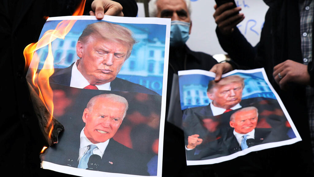 Protesters burn pictures of U.S. President-elect Joe Biden and U.S. President Donald Trump during a demonstration against the killing of Mohsen Fakhrizadeh,