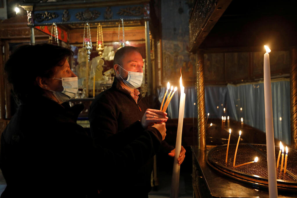 Visitors light candles in the Church of the Nativity, amid the coronavirus disease (COVID-19) outbreak, in Bethlehem in the Israeli-occupied West Bank 