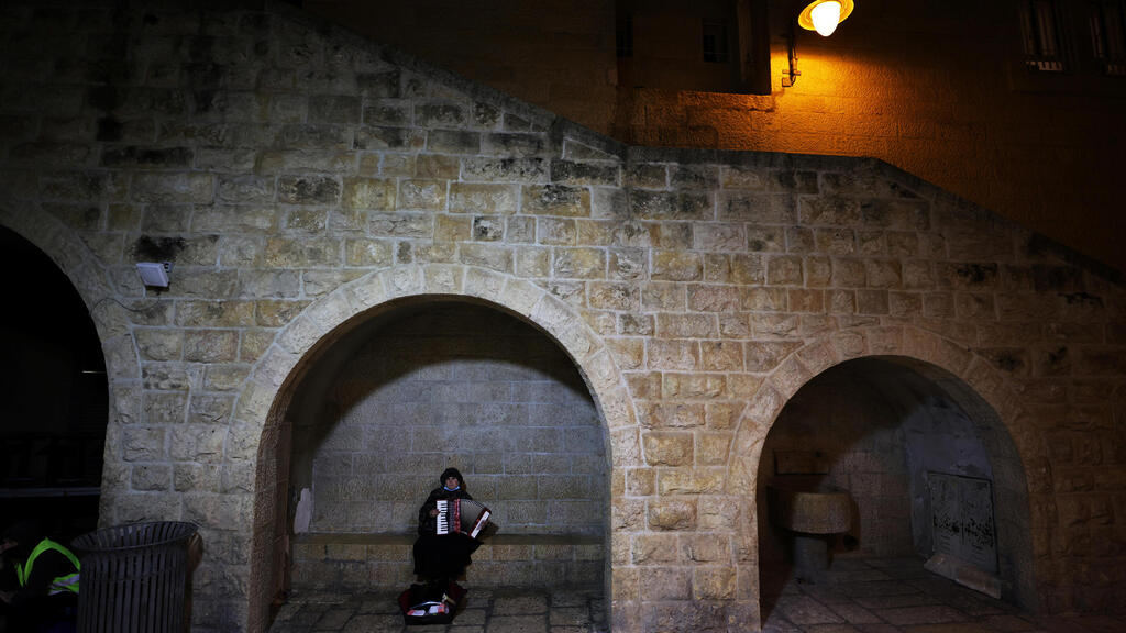 Man plays the accordion at night in Jerusalem's Old City amid coronavirus crisis